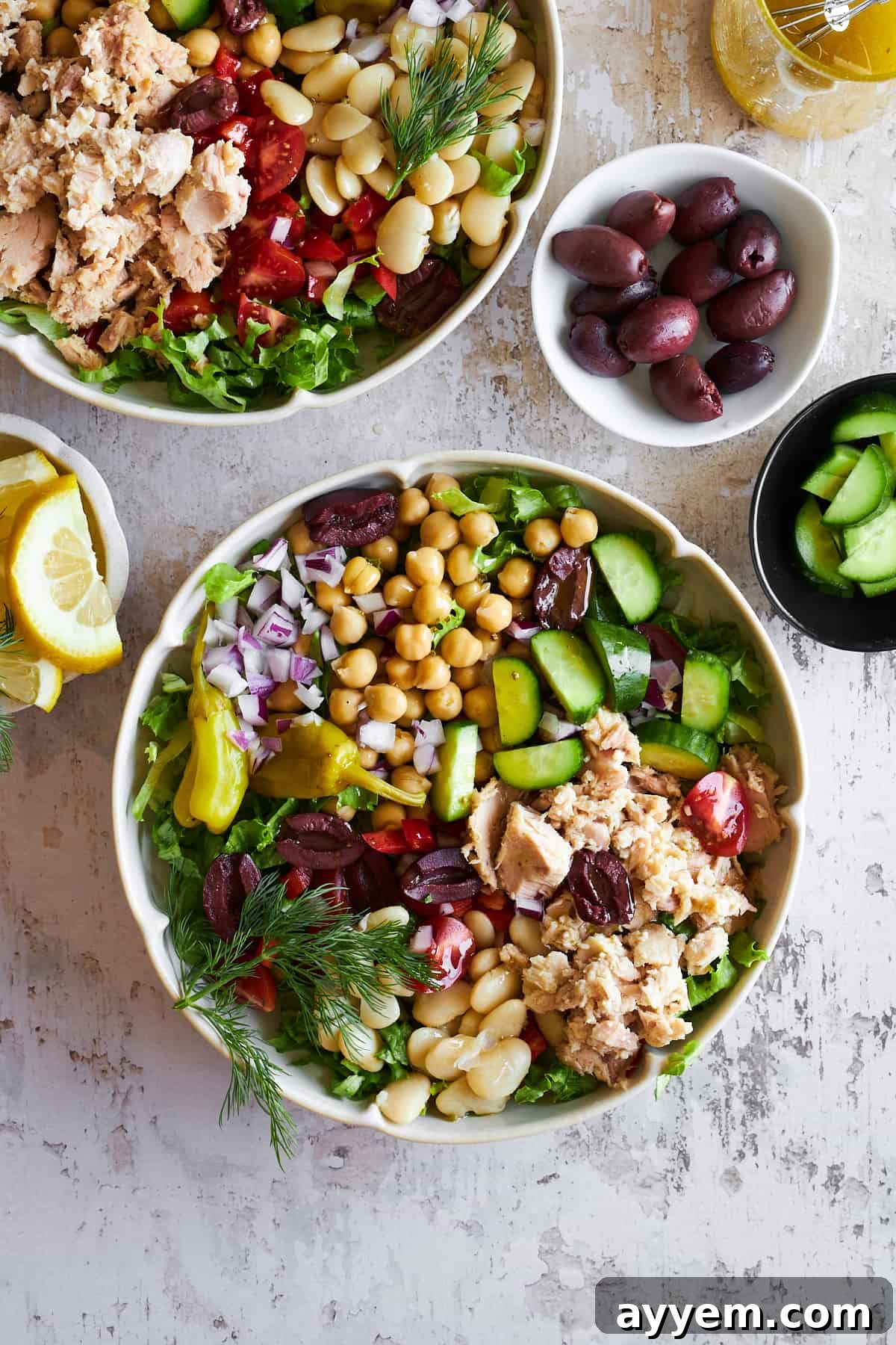 A vibrant bowl of Mediterranean tuna salad, garnished with fresh herbs.