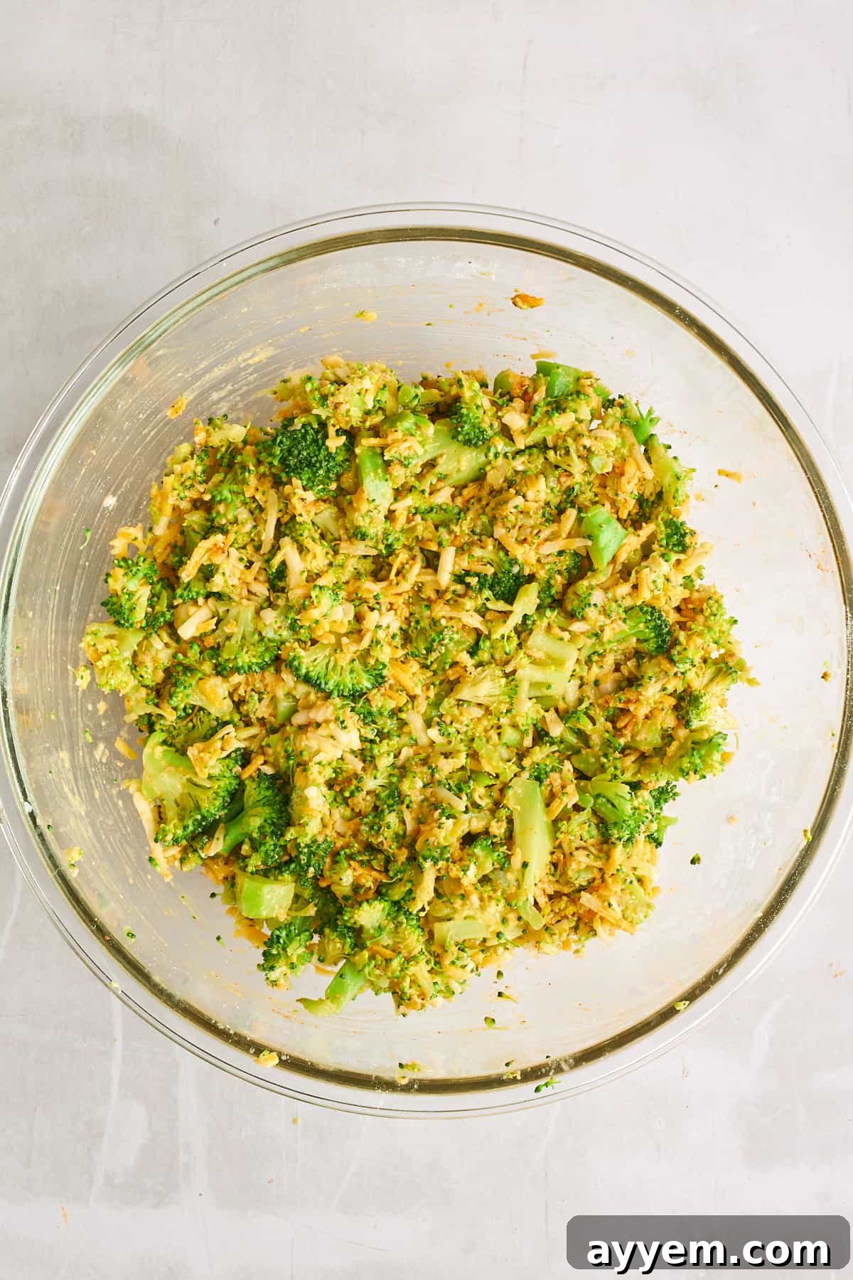 The cheesy broccoli fritter batter in a large mixing bowl, perfectly combined.