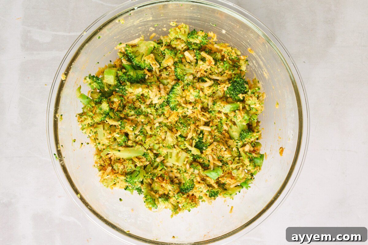 Cheesy broccoli fritters batter in a small bowl.