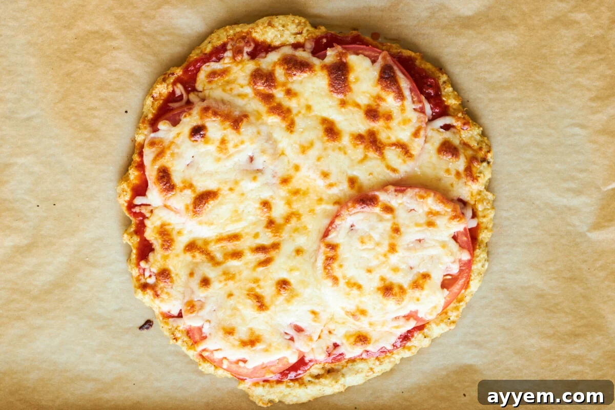 Baked chicken crust pizza with cheese and tomatoes.