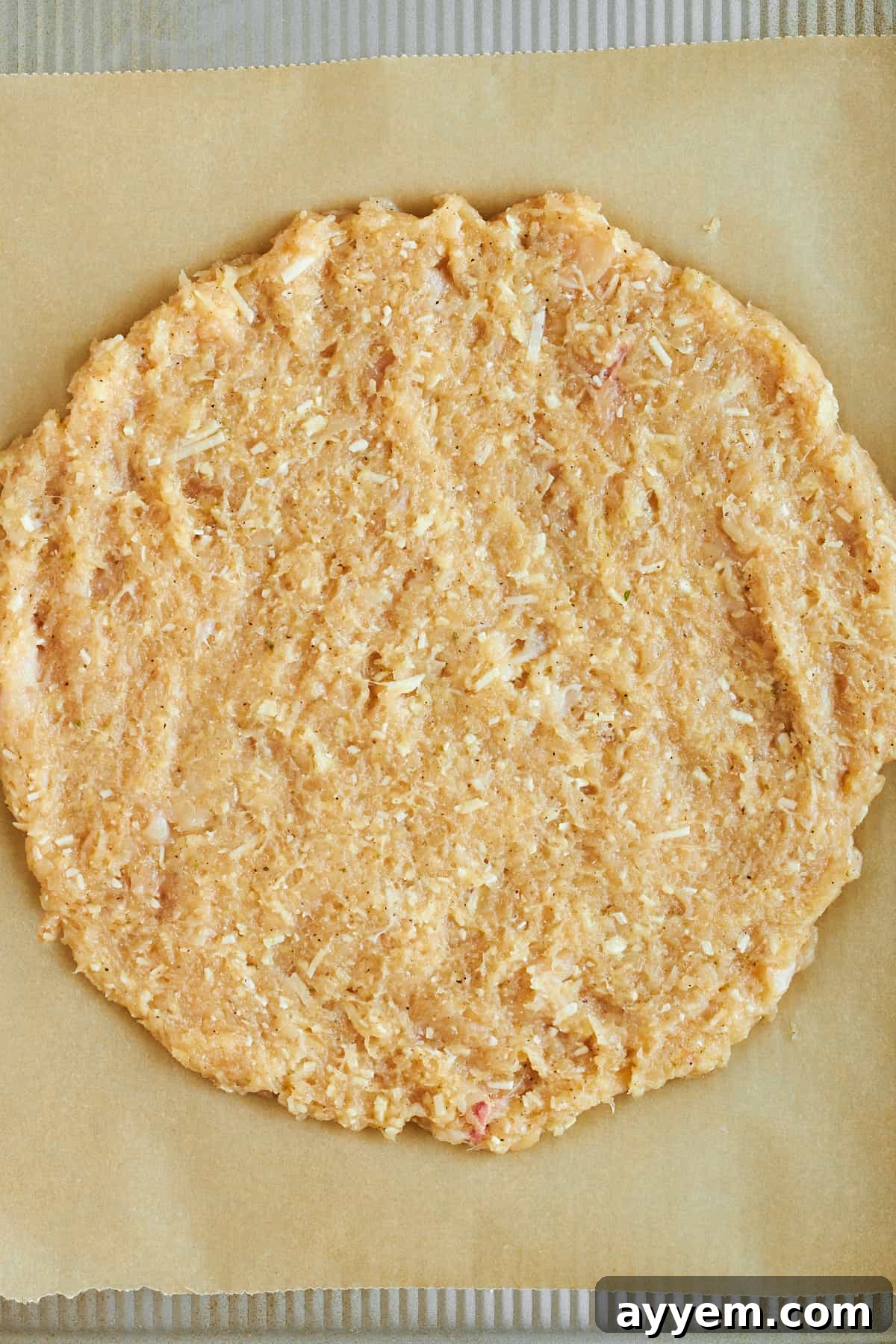 Crispy Chicken Crust Pizza 5 Raw chicken crust shaped on a baking sheet, ready for the oven.