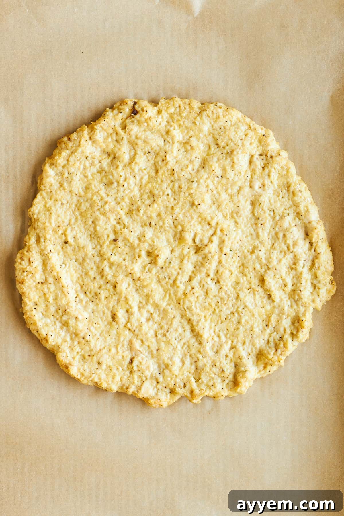 Crispy Chicken Crust Pizza 6 Baked chicken pizza crust on a baking sheet, showing its golden-brown edges.