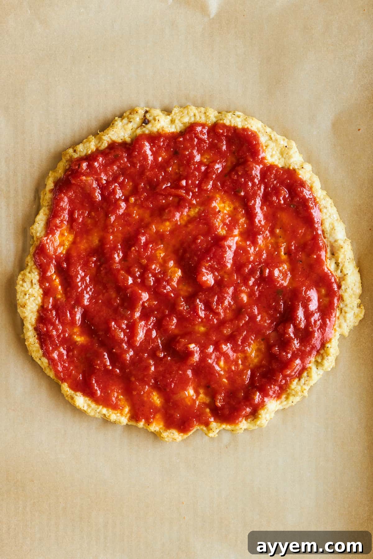 Crispy Chicken Crust Pizza 7 Chicken pizza crust topped with marinara sauce, spread evenly to the edges.