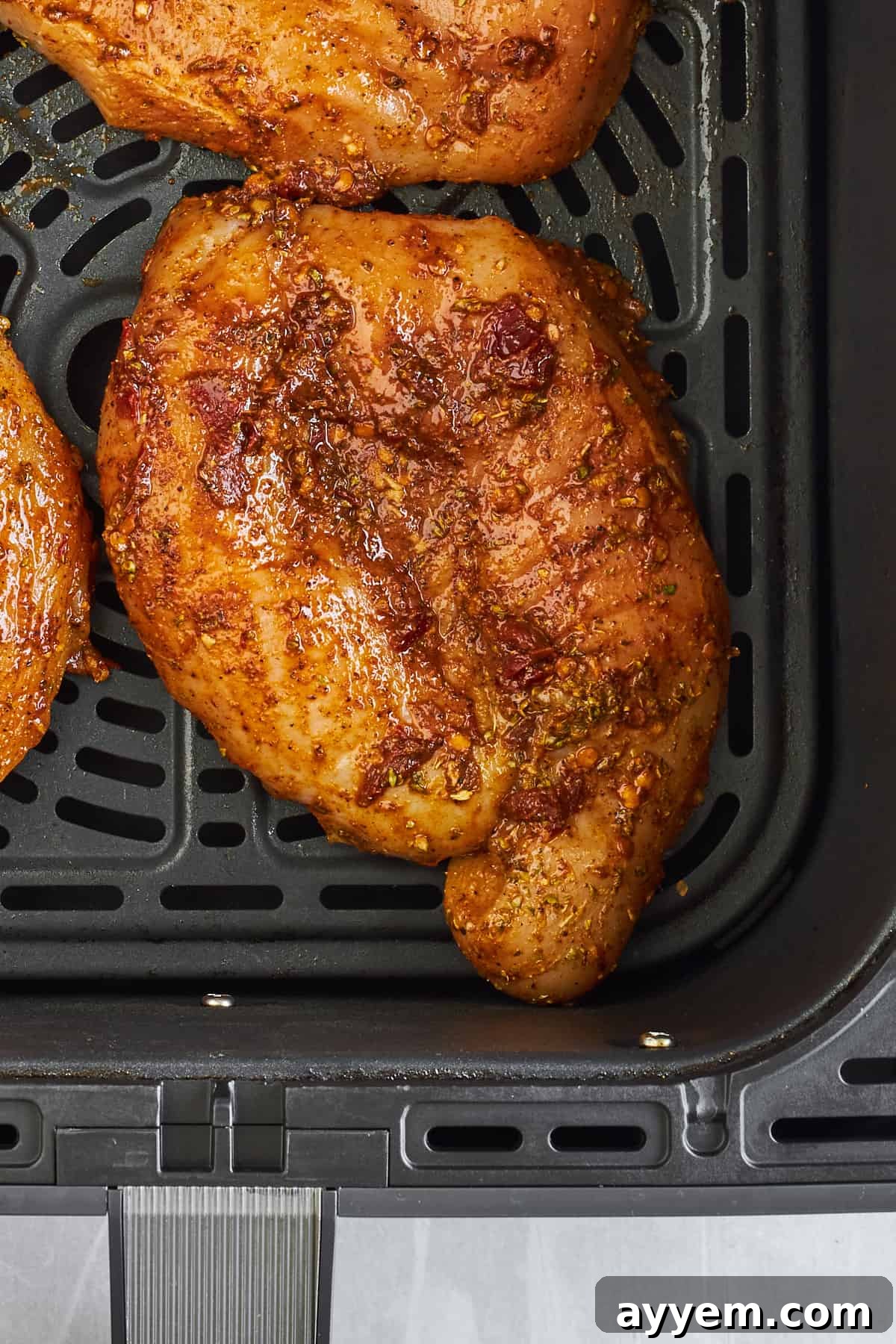 Raw chipotle chicken thighs in an air fryer. 