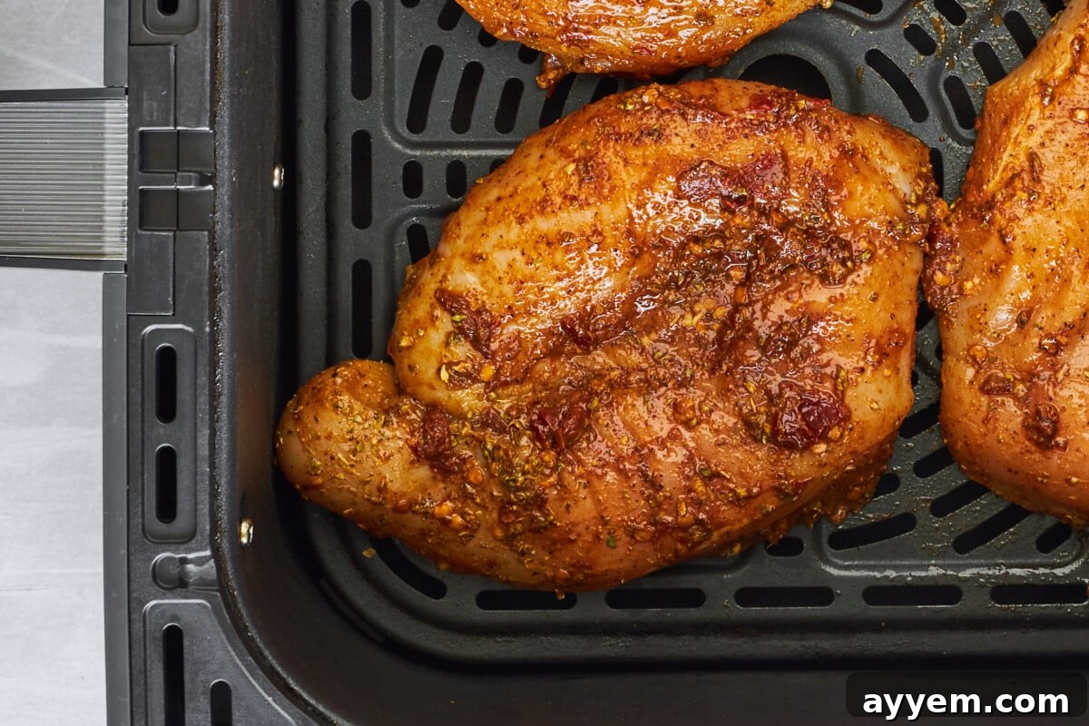 Raw chipotle chicken thighs in an air fryer.