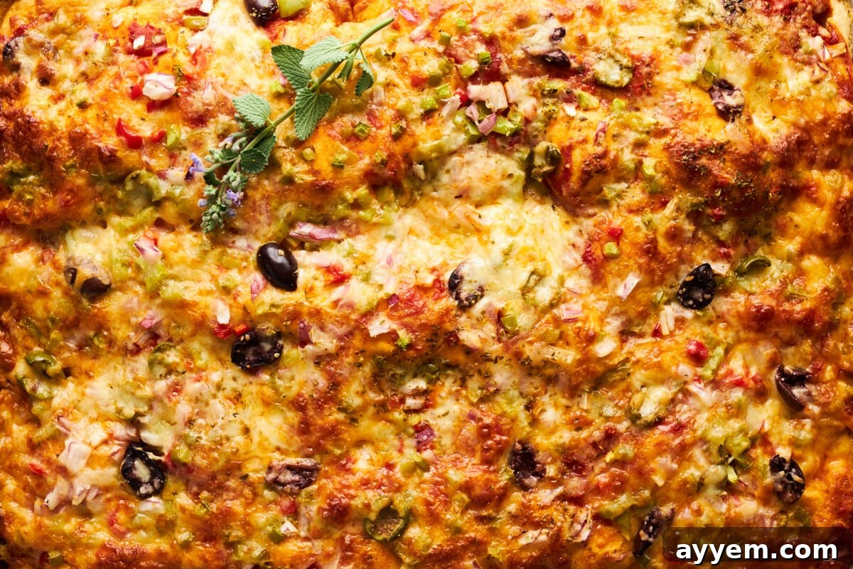 Freshly baked sheet pan pizza with golden crust and melted cheese.