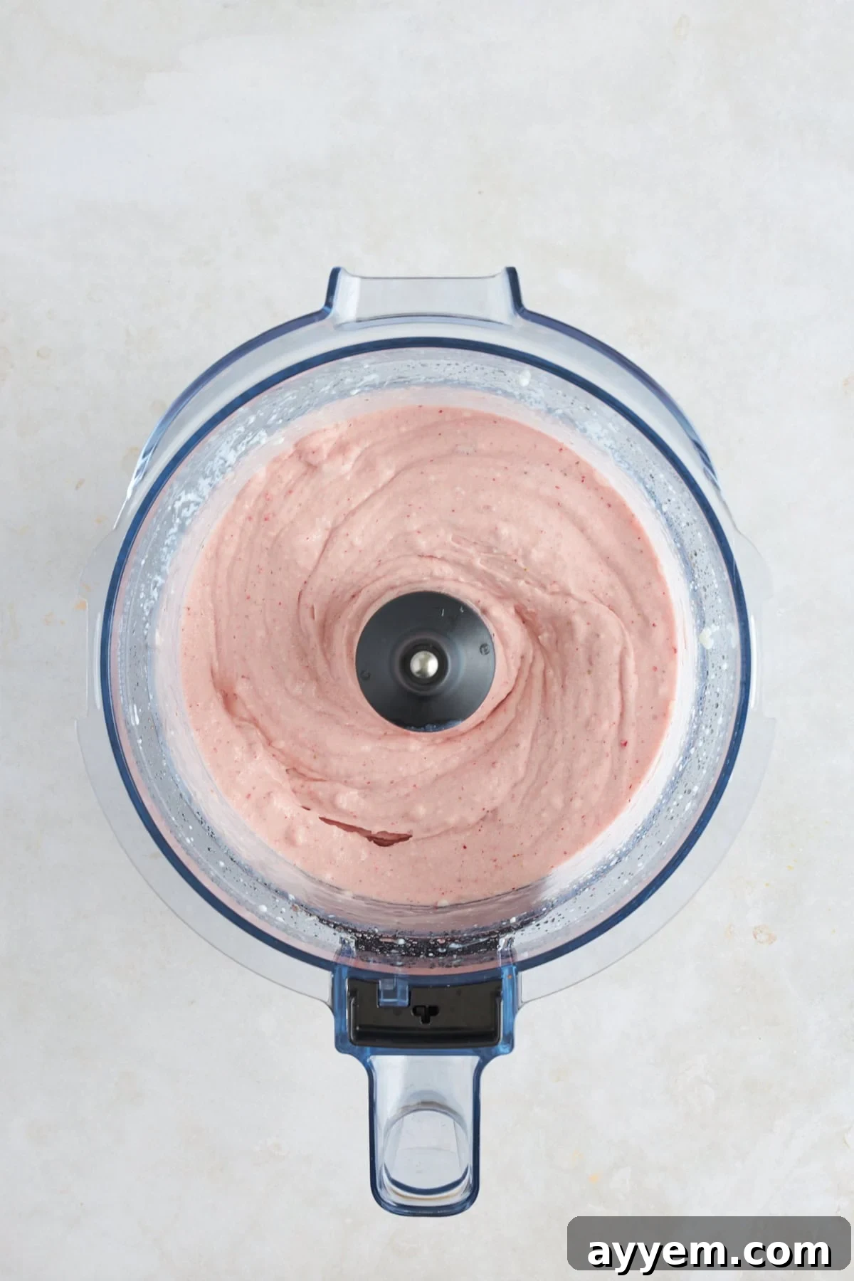 A close-up of the freshly blended cottage cheese ice cream mixture being scooped into a container.