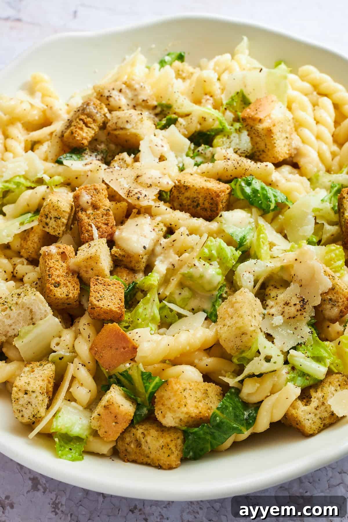 Zesty Caesar Pasta Bowl 4 Close up image of a bowl of Caesar pasta salad.