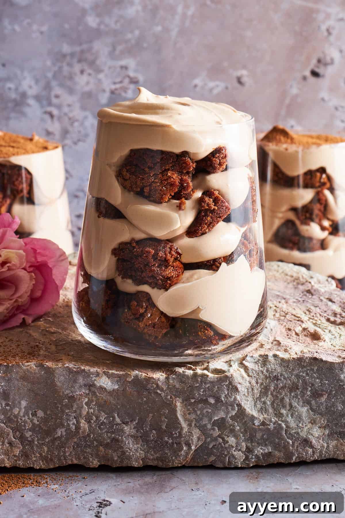 Three tiramisu brownie parfait cups, showcasing the beautiful layers of brownie and cream.