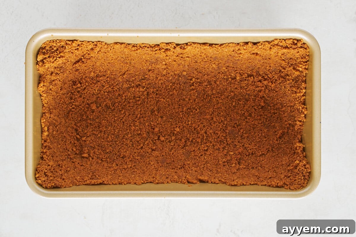 Biscoff crust pressed into a loaf pan.