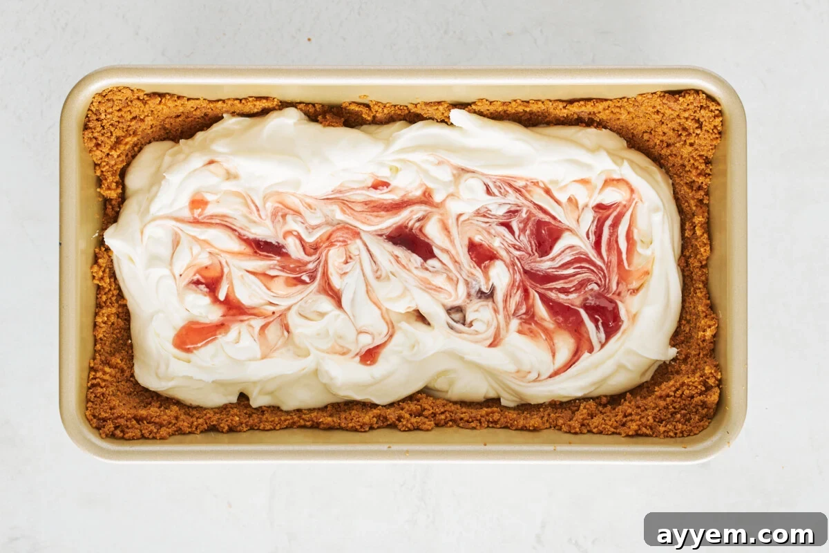 Biscoff crust filled with cream cheese filling swirled with strawberry preserves.