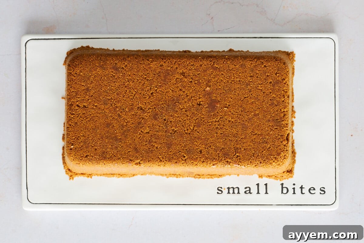 Upside-down cheesecake on a plate, ready to be sliced.