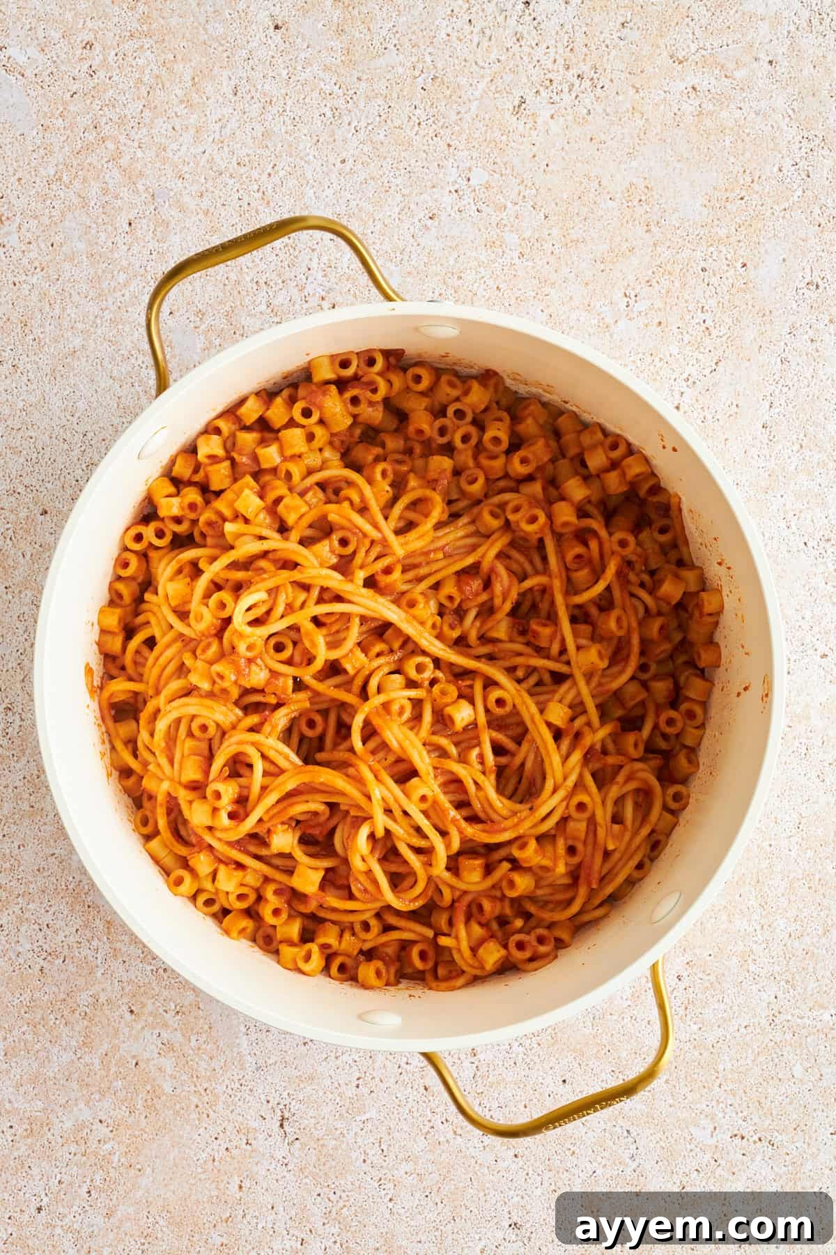 A large pot filled with uncooked spaghetti and ditalini pasta, ready for boiling.