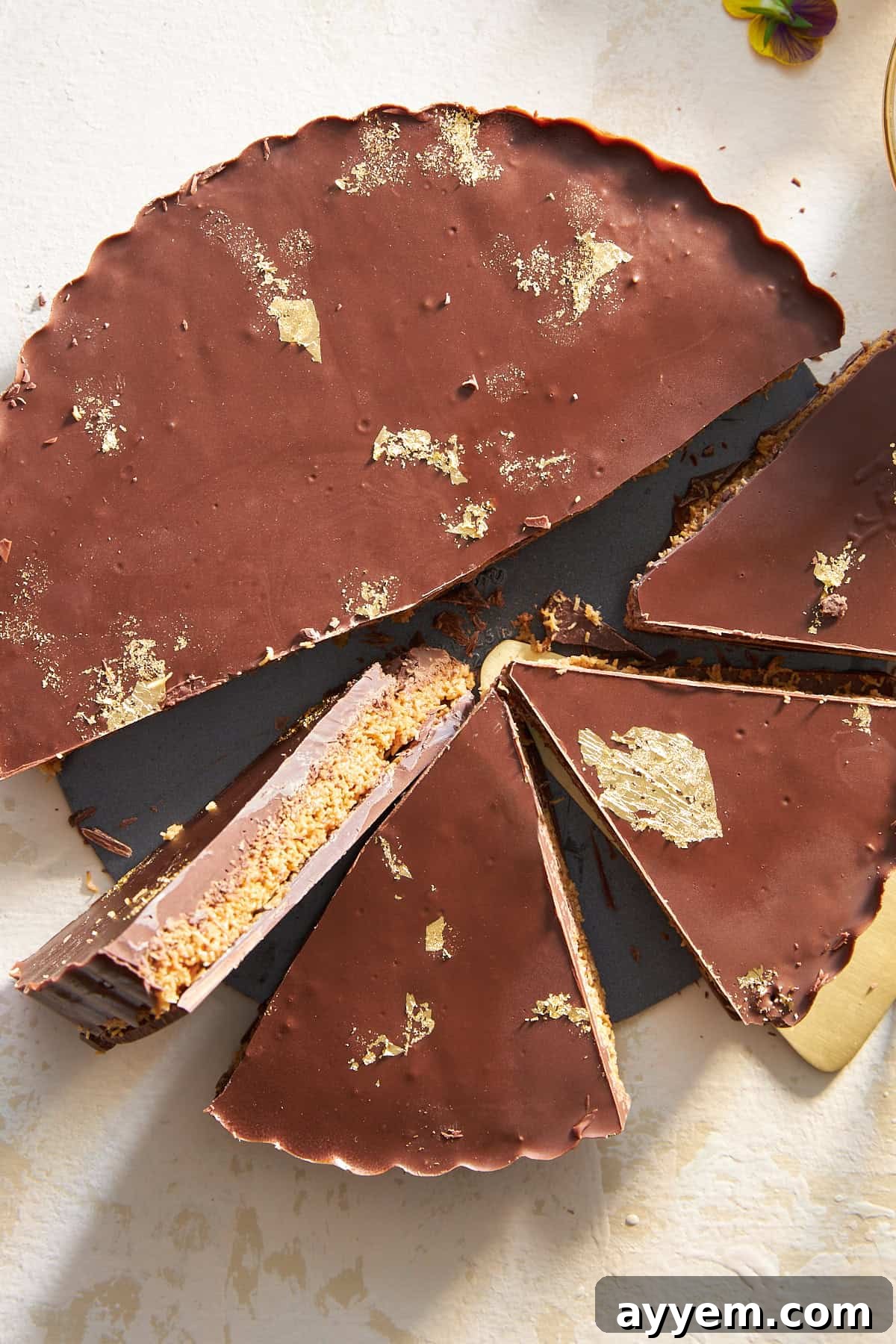 A chocolate peanut butter kunafa with four pieces already sliced, revealing the distinct layers.