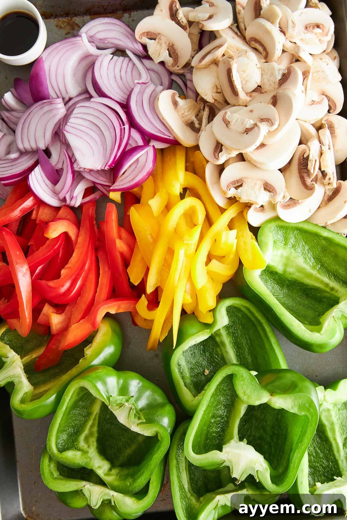Sliced bell peppers, green bell pepper halves, mushrooms, and red onions. 