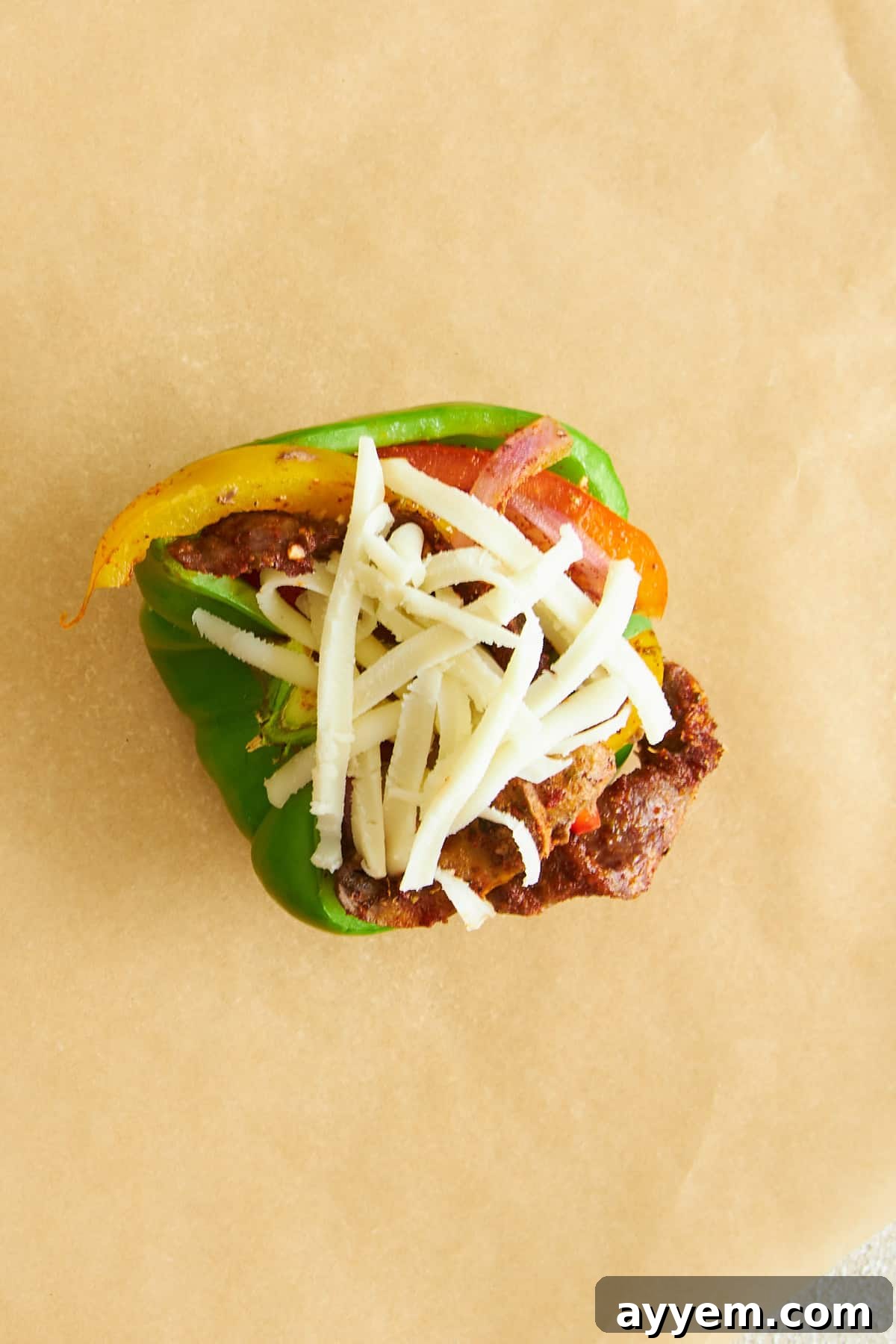 An uncooked Philly cheesesteak stuffed pepper. 