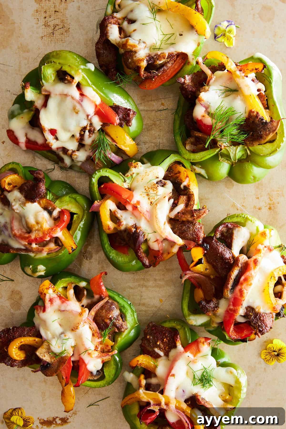 Philly cheesesteak stuffed peppers on a baking sheet. 