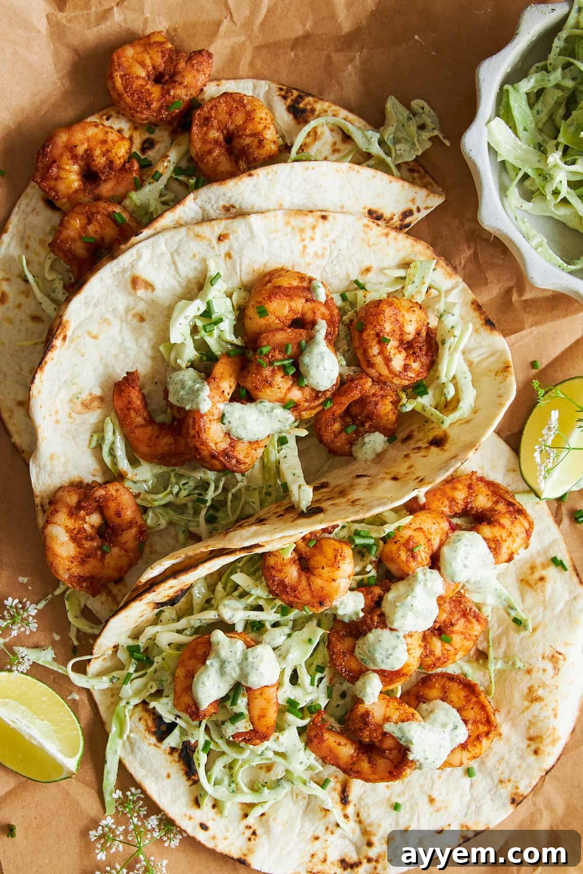 Three perfectly assembled blackened shrimp tacos, showcasing the vibrant colors of the slaw and the rich char of the shrimp.
