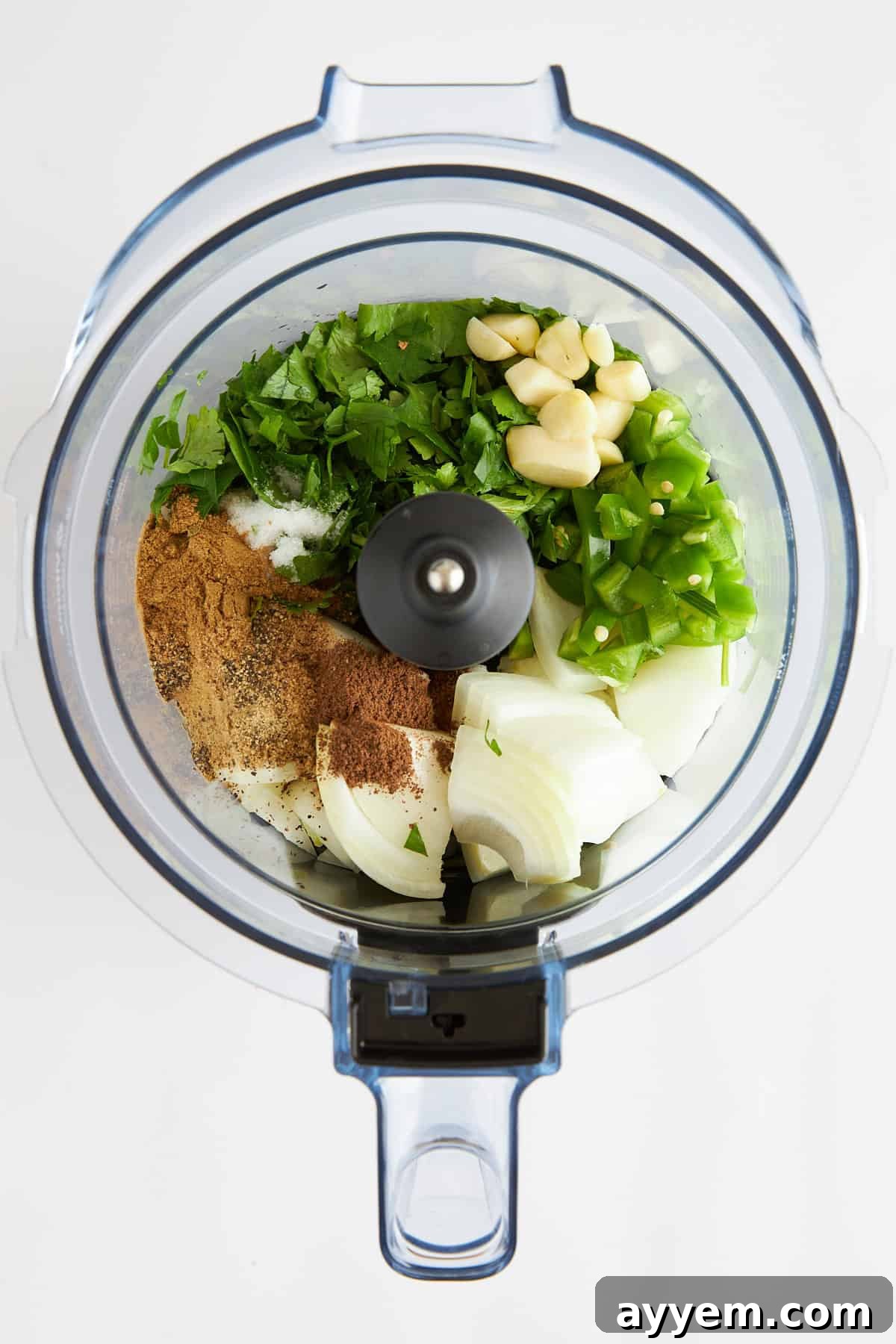 Ingredients for lamb kofta burgers being processed in a food processor, highlighting the fresh herbs and spices.