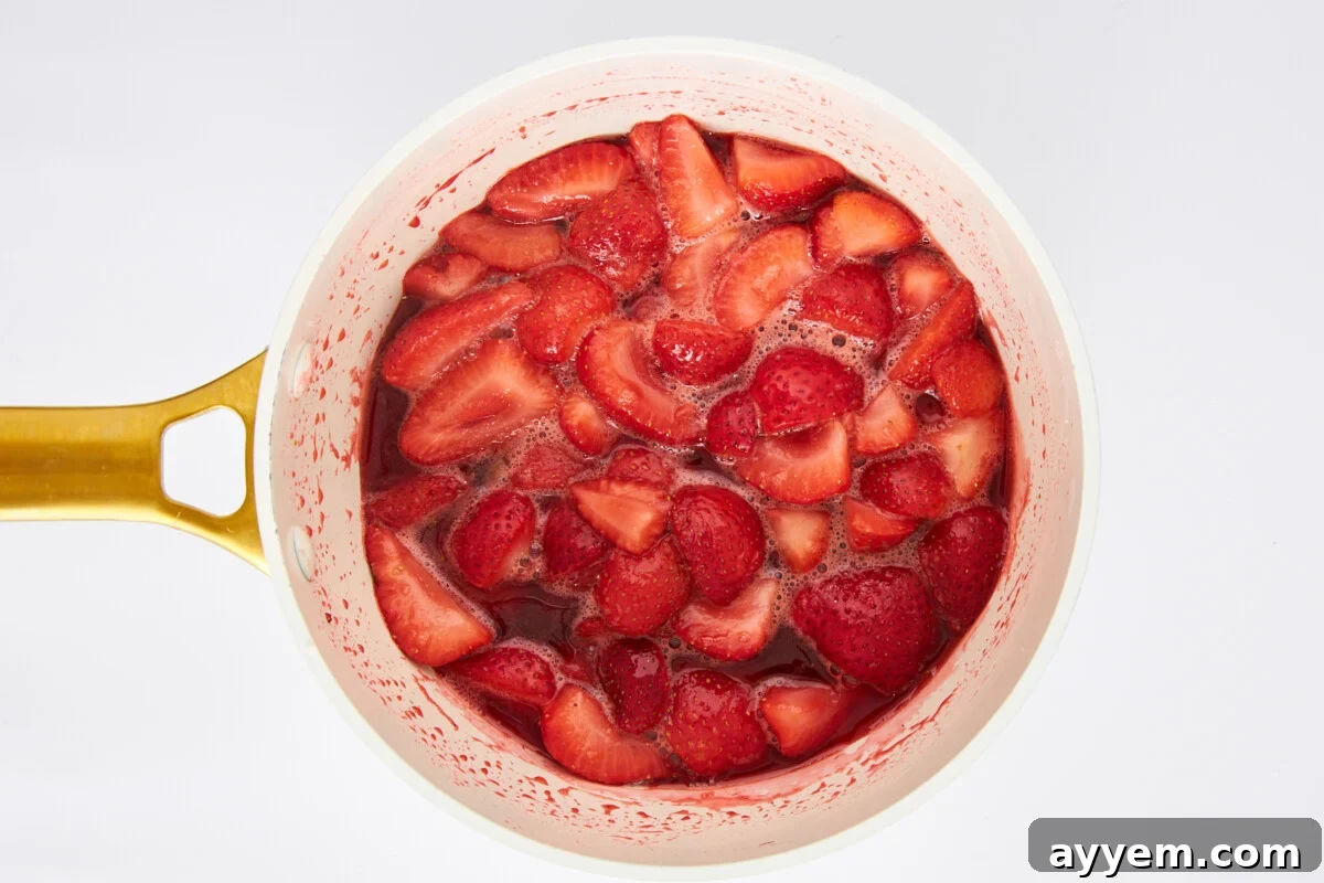 Strawberries cooking in a saucepan.