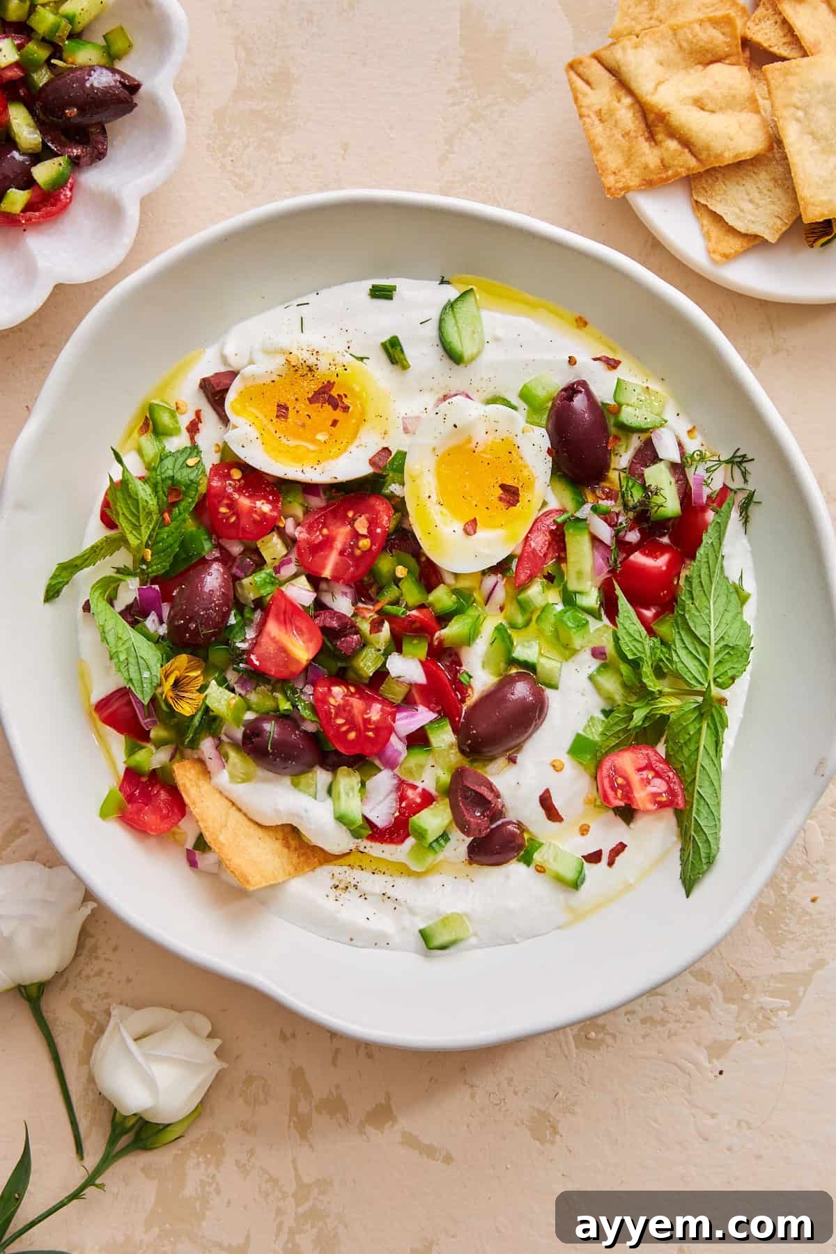 A bowl of whipped cottage cheese salad, generously topped with an array of fresh vegetables and a perfectly cooked egg, ready to be enjoyed.