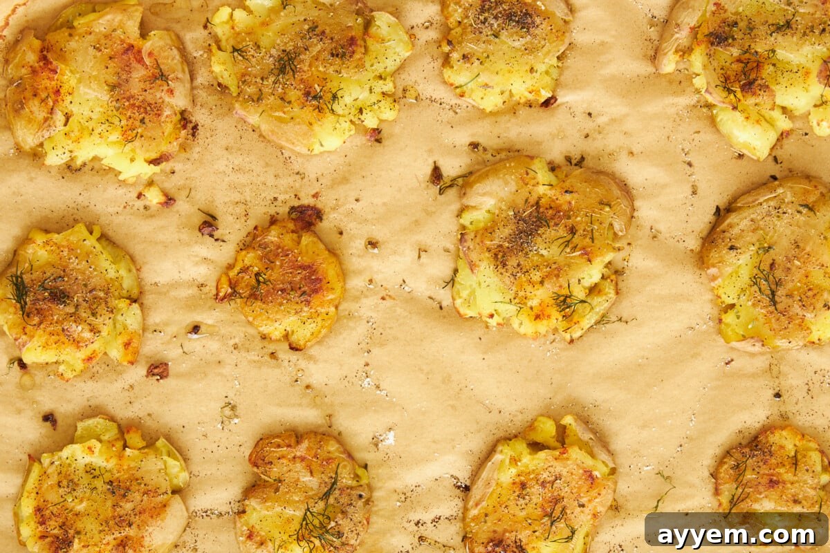 Baked crispy potatoes on a parchment-lined baking sheet.