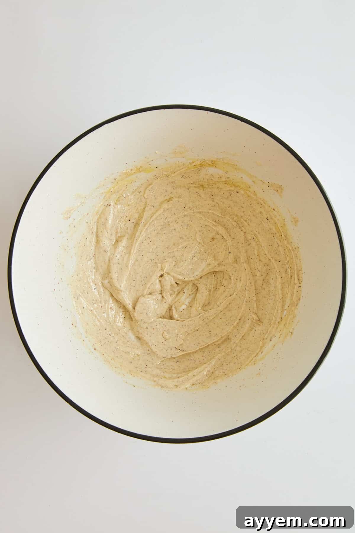Tahini yogurt chicken marinade in a bowl, showing its creamy texture.
