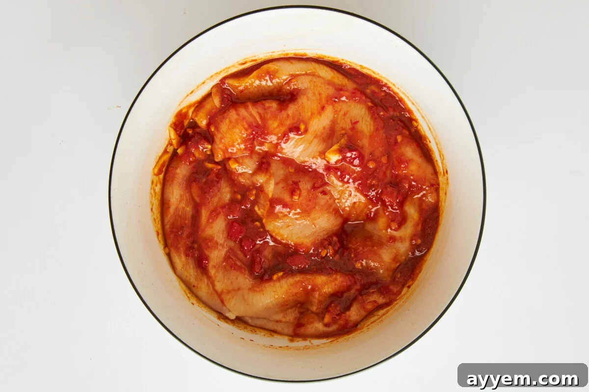 Chicken marinading in honey harissa sauce.