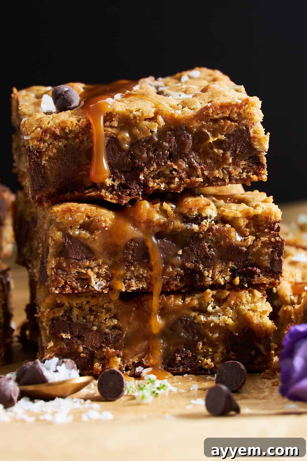 Three chocolate chip caramel bars stacked on top of each other.