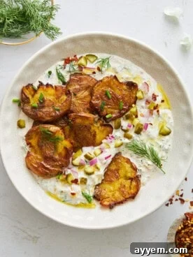 A bowl of innovative Labne crispy potato salad, showing golden-brown smashed potatoes tossed with a creamy, tangy dressing.