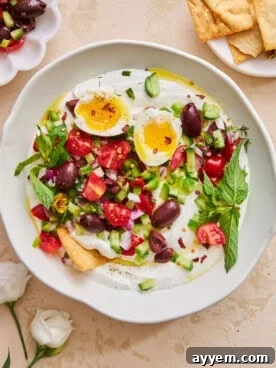 A visually appealing bowl of Mediterranean whipped cottage cheese salad, topped with fresh vegetables and a perfectly runny egg.