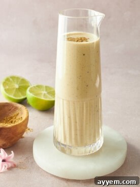 A container filled with creamy tahini dressing, showcasing its smooth texture and rich color, ready to be drizzled over various dishes.