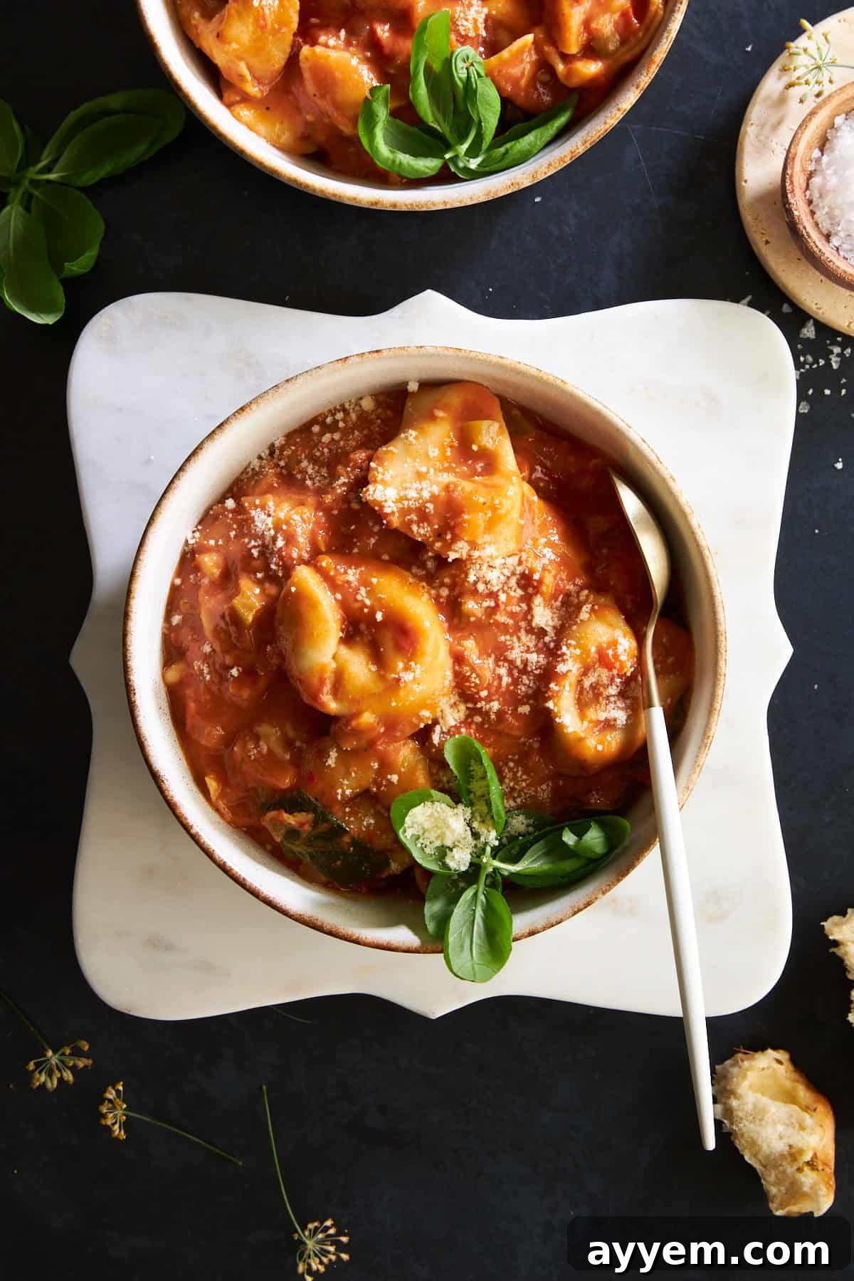 Overhead image of a bowl of cheese tortellini soup.