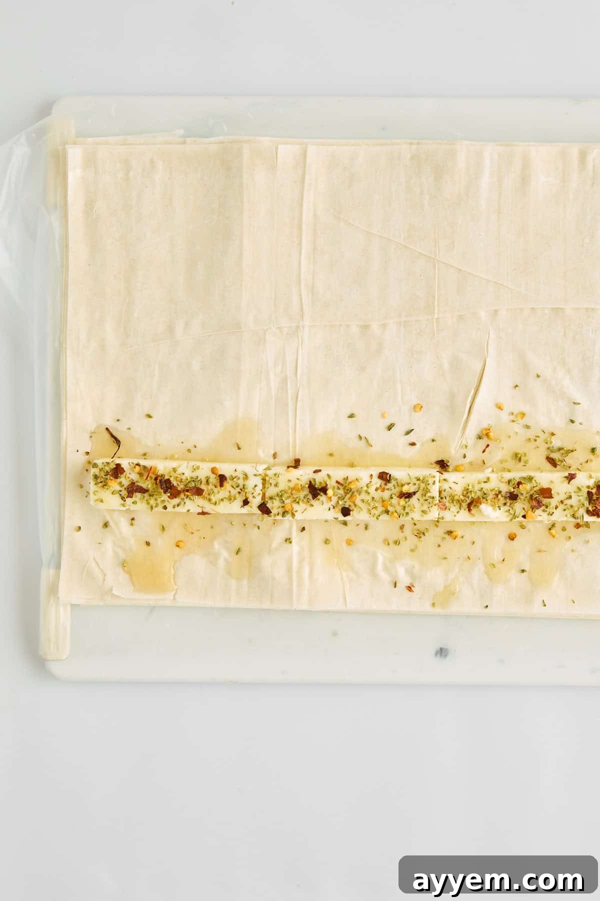 Crumbled feta cheese and a honey drizzle laid out on delicate phyllo dough sheets.