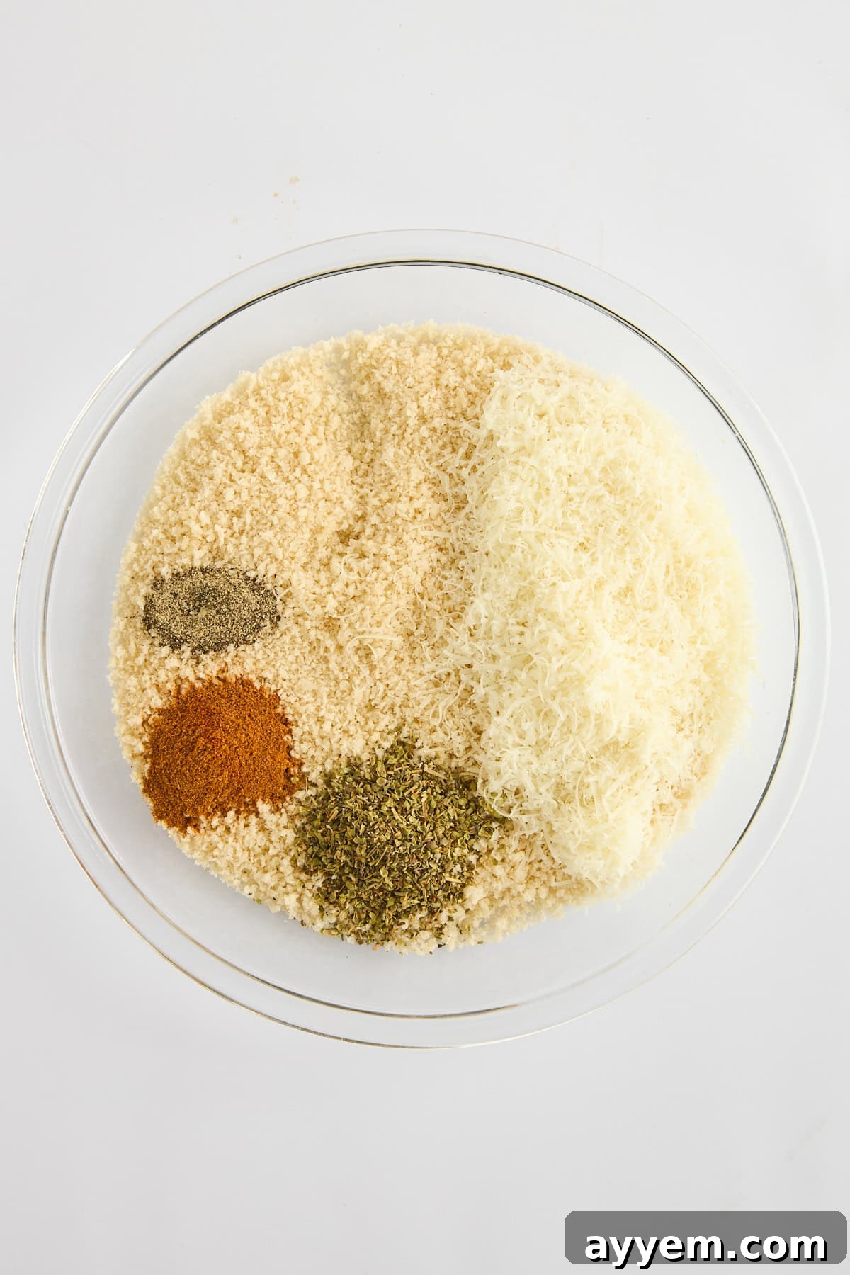 A bowl of seasoned panko breadcrumbs, mixed with Parmesan, Italian seasoning, and paprika, ready for coating chicken.