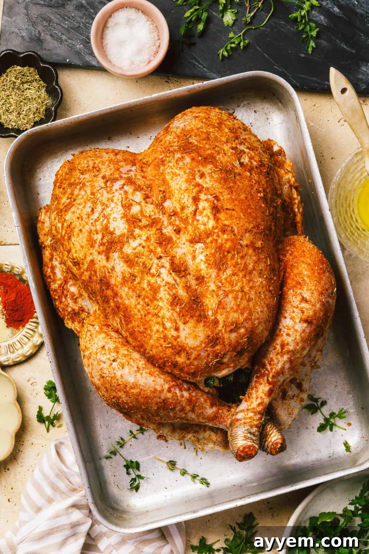A whole roasted turkey presented on a rustic wooden board.