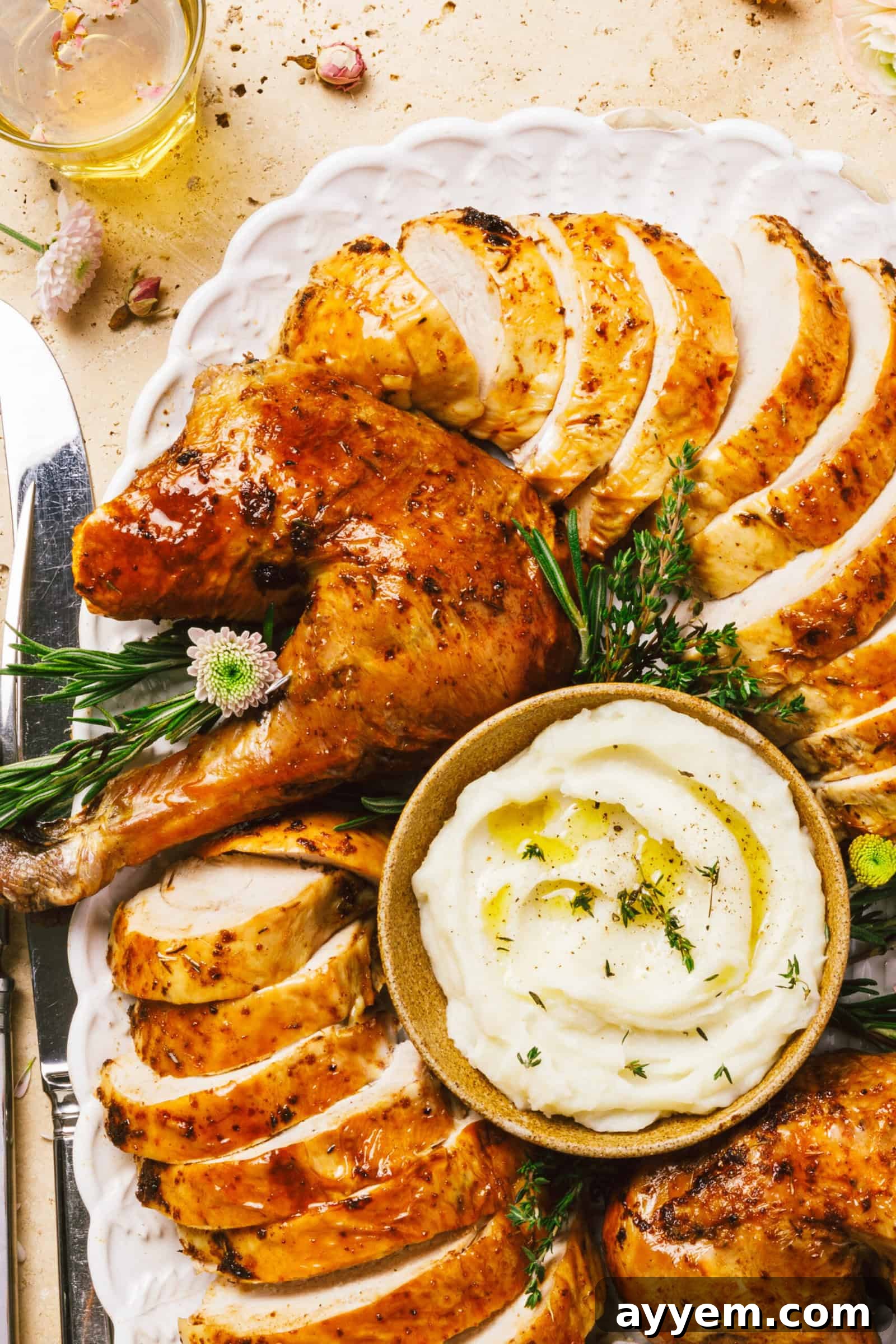 A beautifully roasted whole turkey on a serving platter, garnished with fresh herbs.
