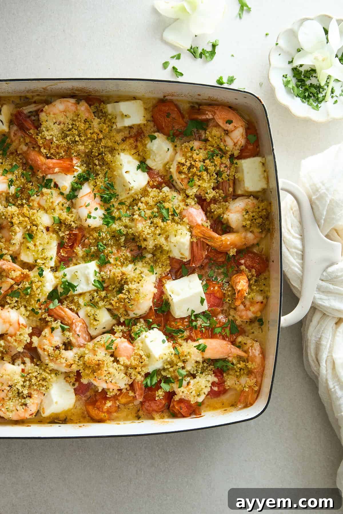 Close-up of baked Panko Shrimp and Feta Bake, golden brown and garnished with fresh herbs.