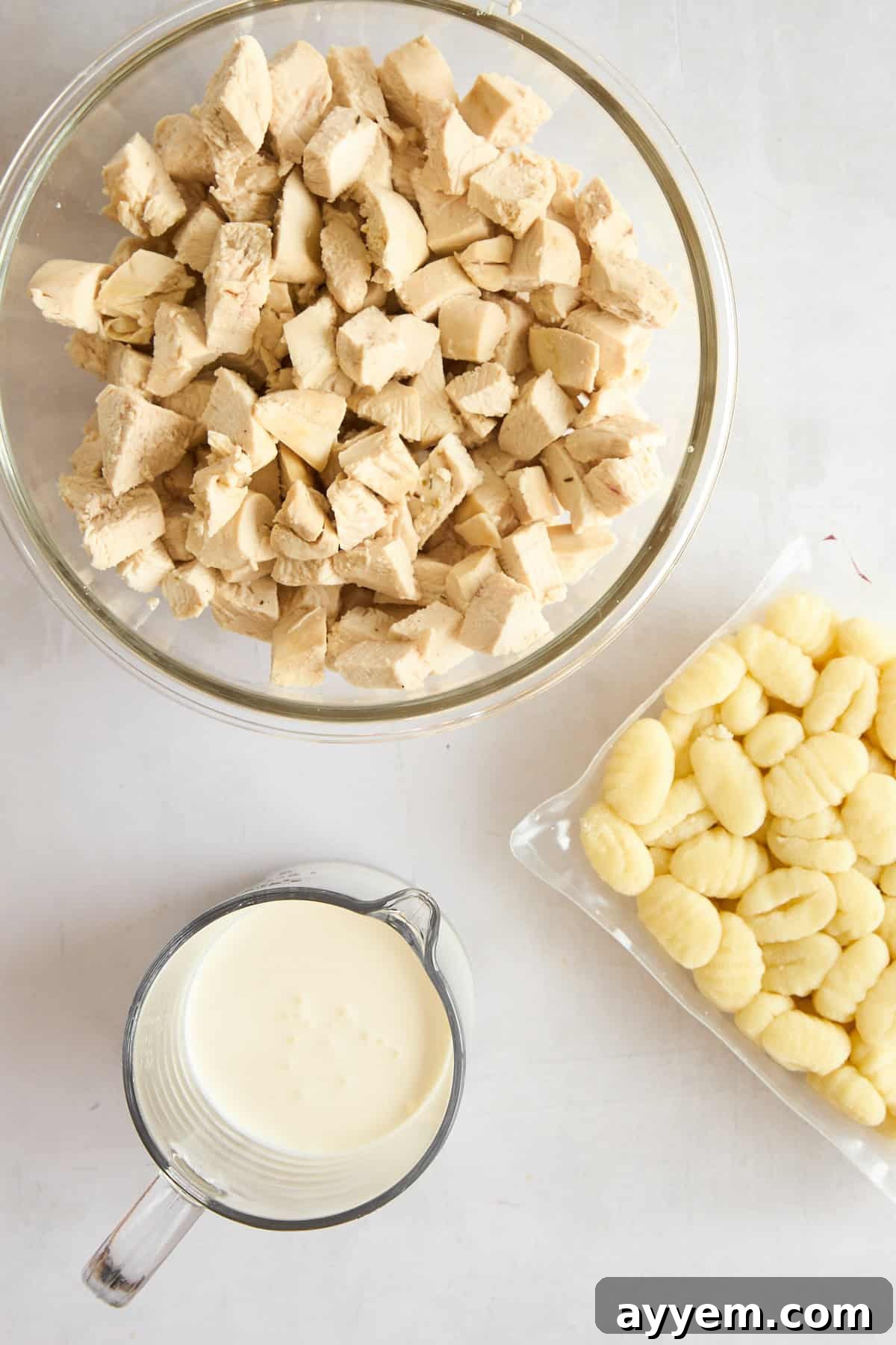 Shredded chicken pieces and potato gnocchi submerged in the creamy soup base.