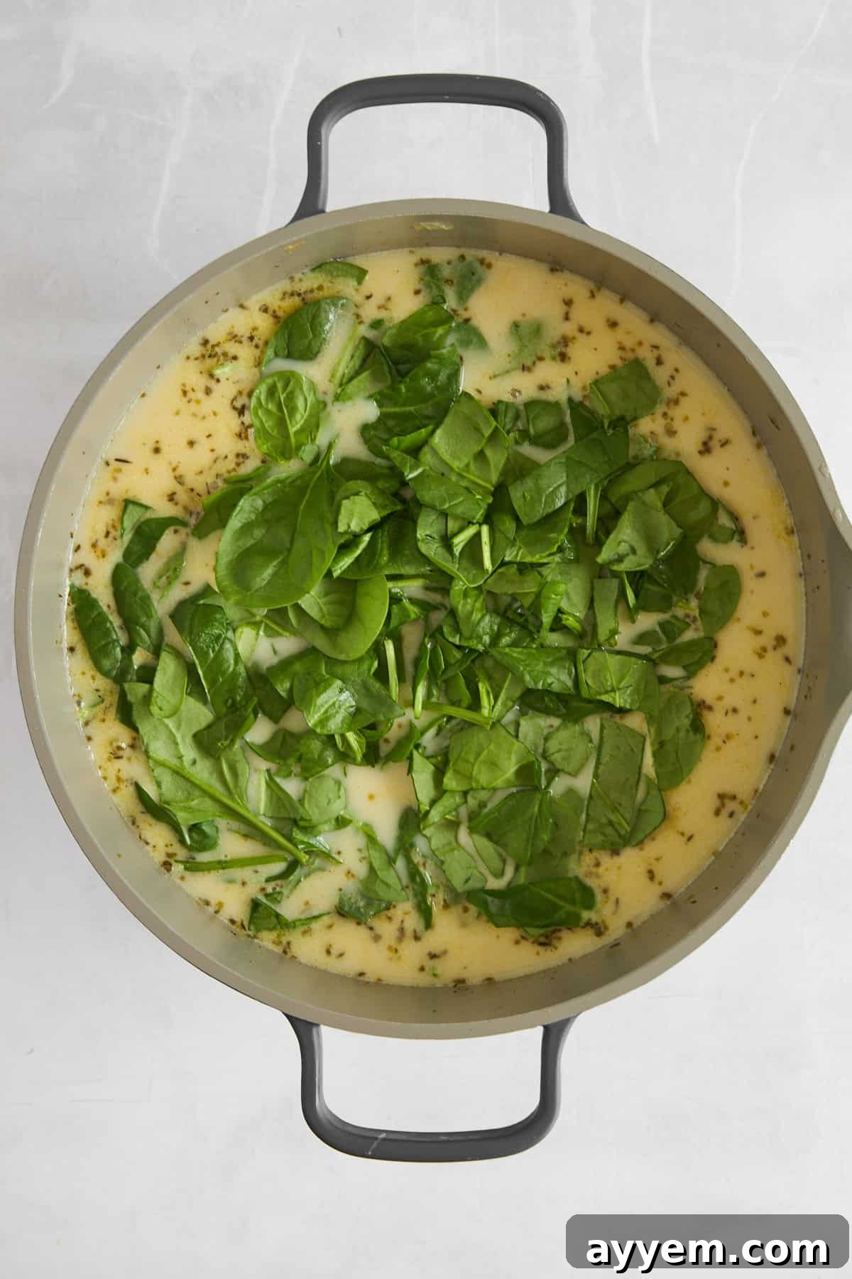 Fresh spinach wilting beautifully into a pot of simmering chicken and gnocchi soup.