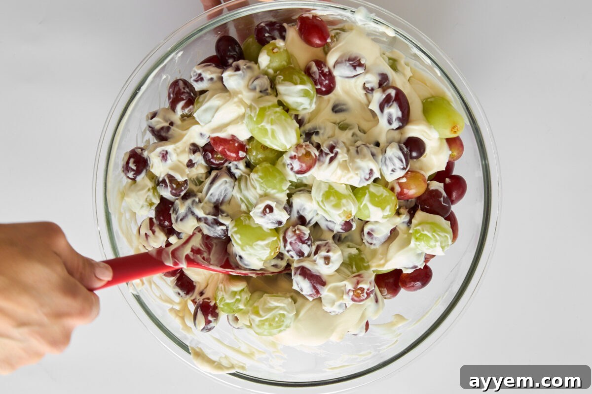 Grape salad being mixed in a bowl.