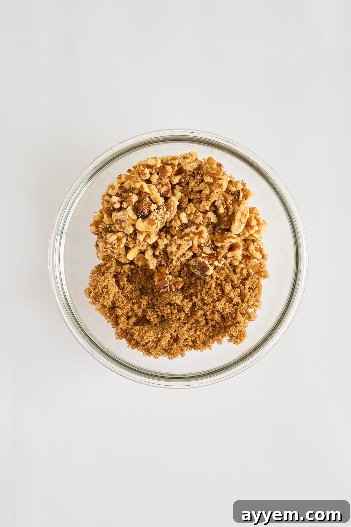 A bowl containing a delicious walnut and brown sugar topping, ready to be sprinkled over the grape salad.