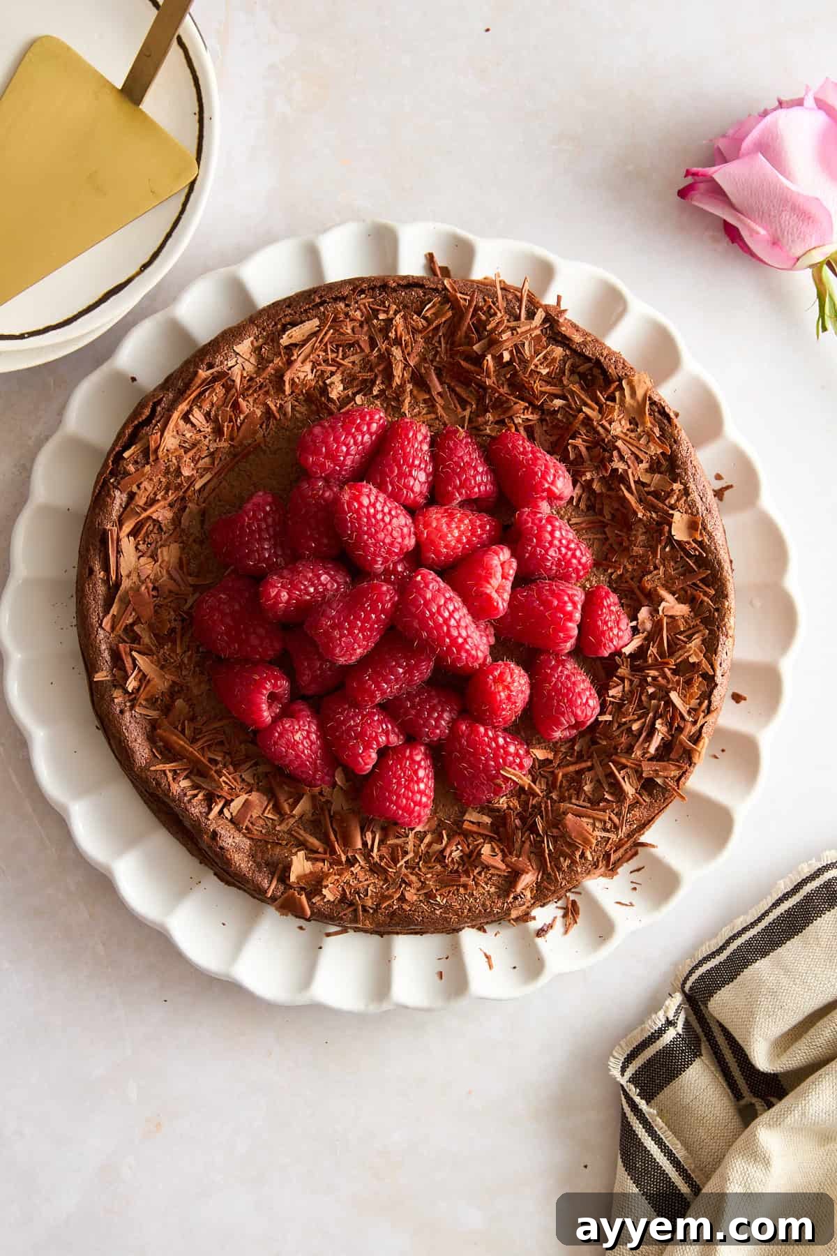 Overhead image of a flourless chocolate cake topped with raspberries.