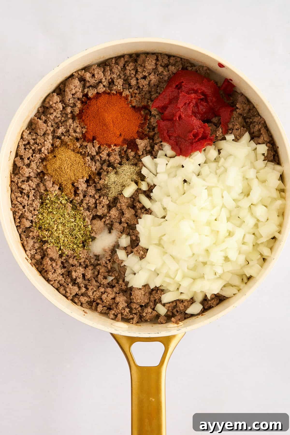 Ground beef, spices, and onions cooking in a pot for Turkish pasta.