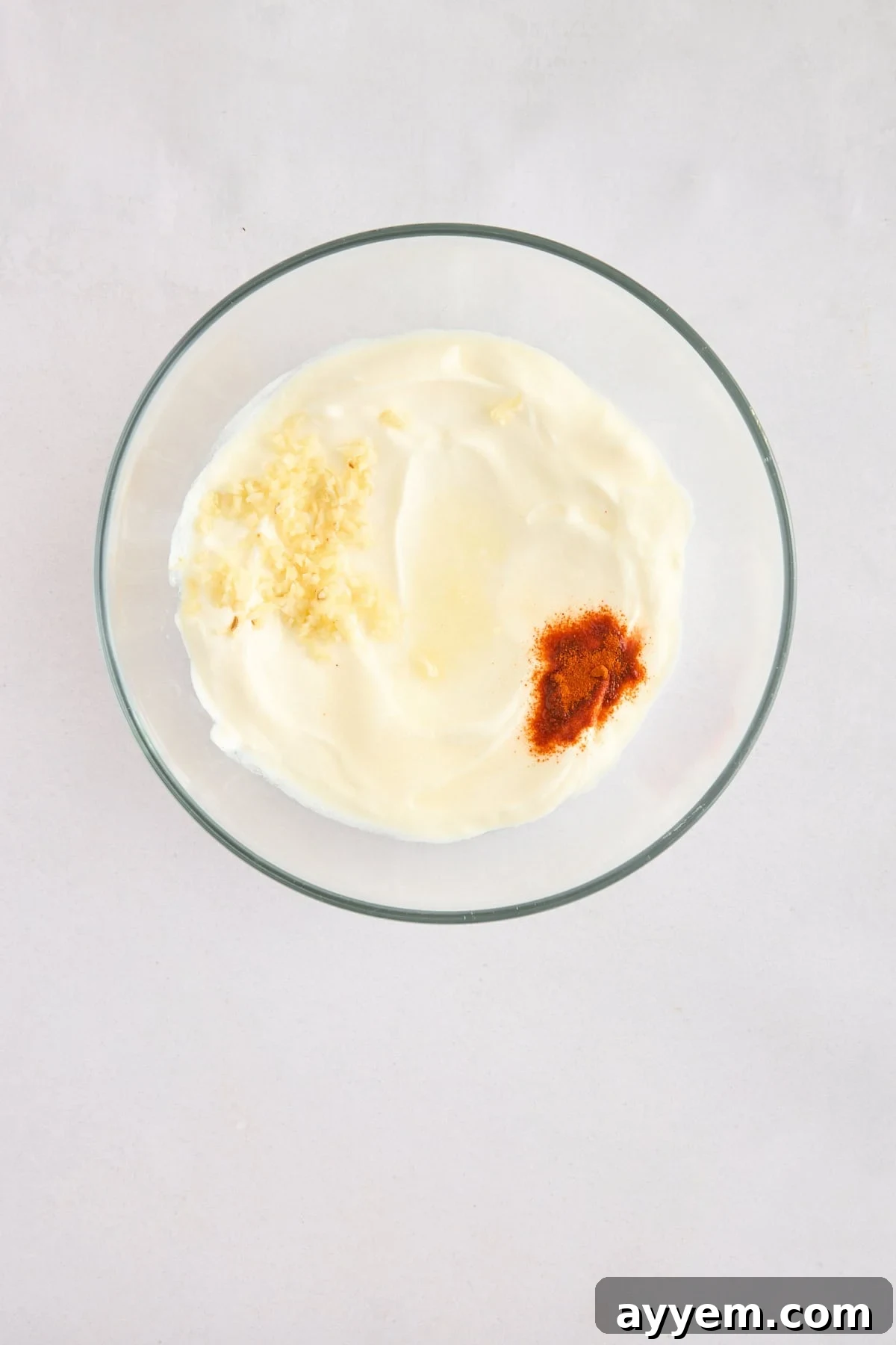 Garlic, yogurt, and spices mixed in a bowl for the sauce.