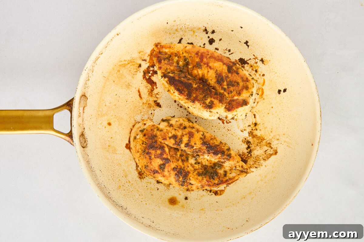 Chicken searing in a skillet.