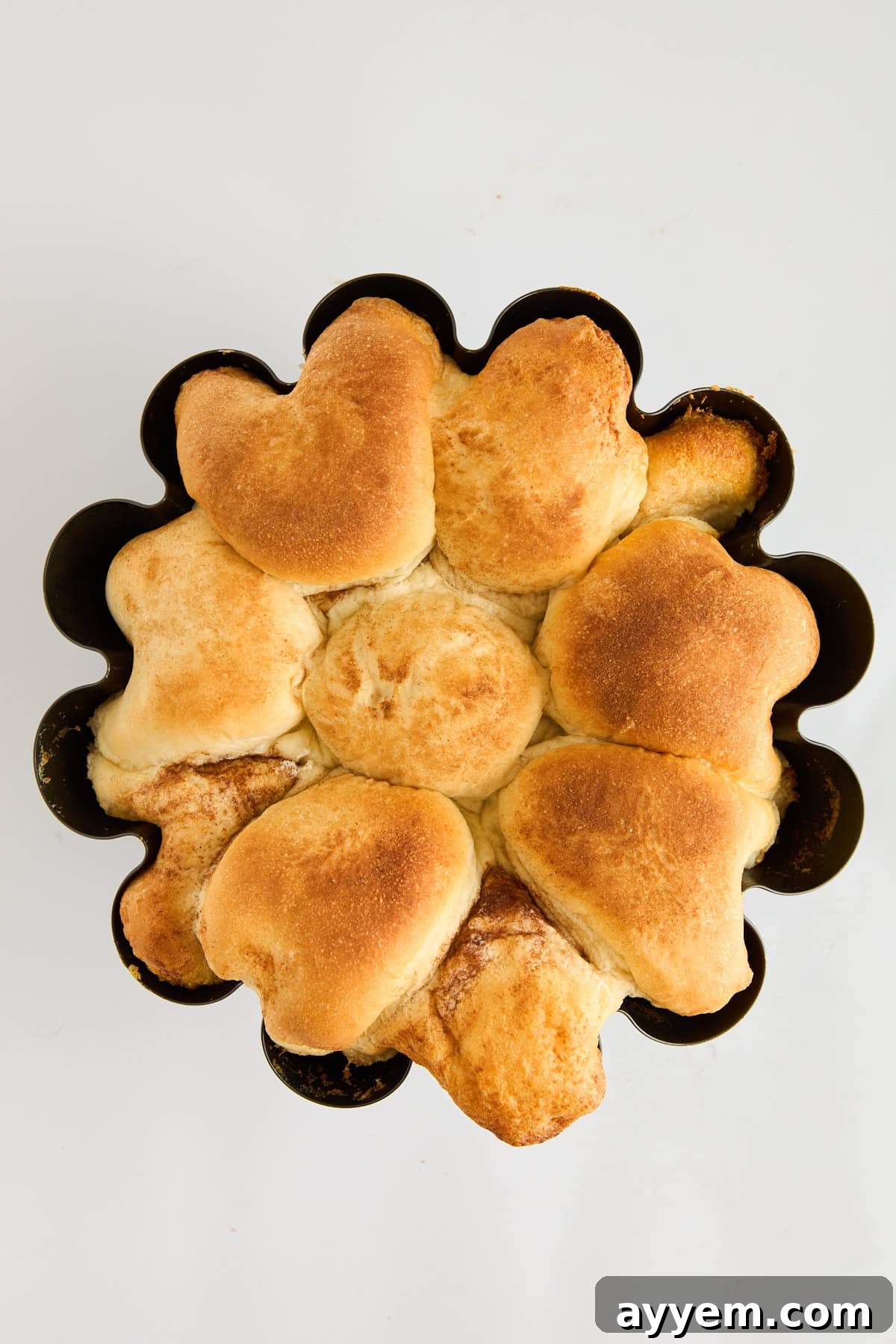 Freshly baked, golden-brown cinnamon sugar pull apart bread still in a Bundt pan, glistening with caramelized sugar.
