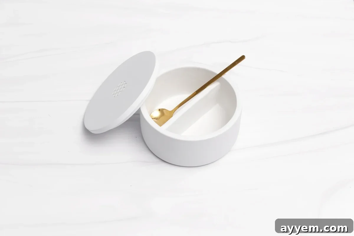 Crafting the Perfect Influencer Box: Our Secrets Revealed 9 A white, round porcelain bowl with a lid sits open on a white marble surface.