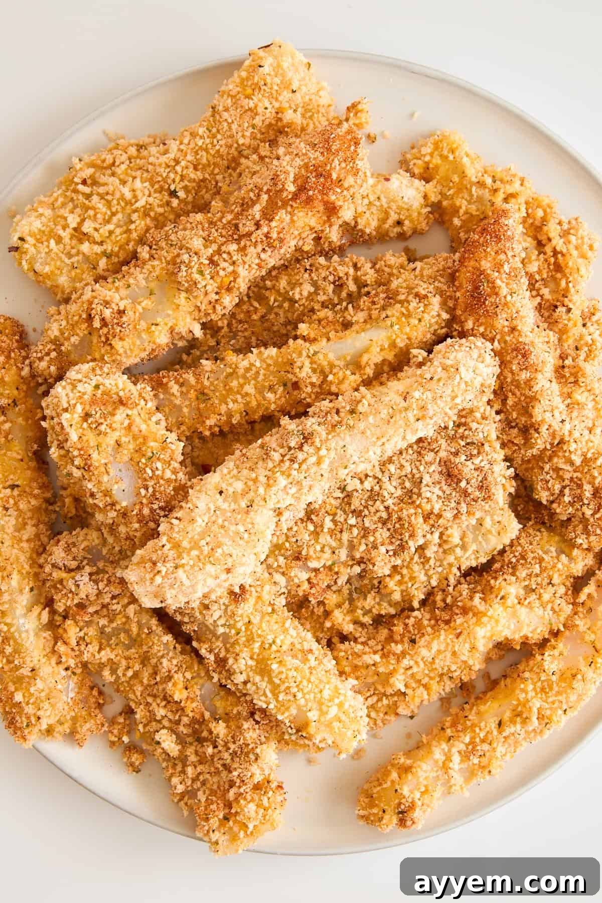 Homemade panko coated fish sticks on a plate, ready to be served.