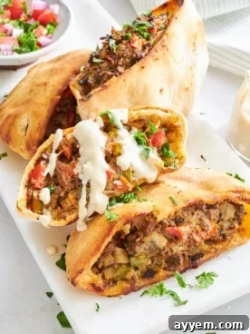 Four Hawawshi pita halves on a plate.